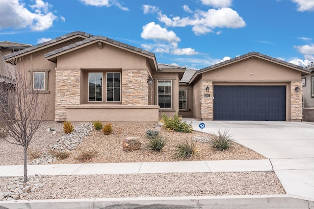 ranch-style home featuring concrete driveway, an attached garage, stone siding, and stucco siding