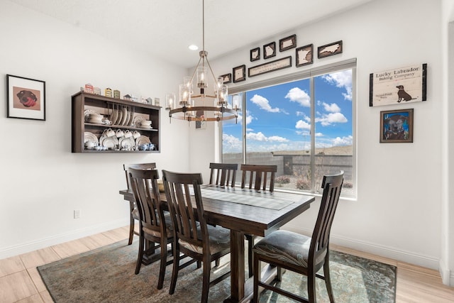 dining room featuring a chandelier, baseboards, and wood finished floors