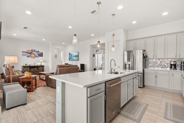 kitchen featuring a sink, stainless steel appliances, visible vents, and open floor plan