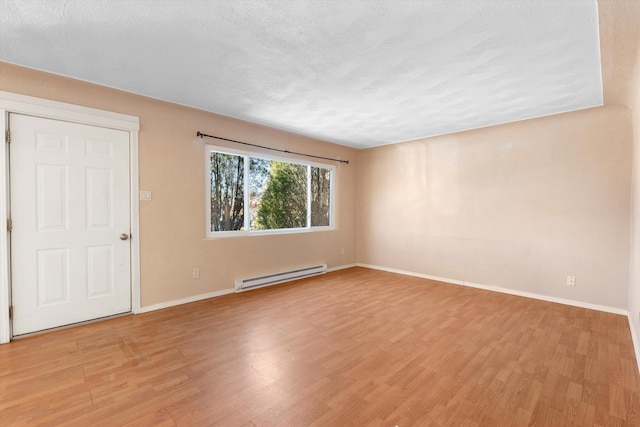 unfurnished room featuring light wood finished floors, baseboards, baseboard heating, and a textured ceiling