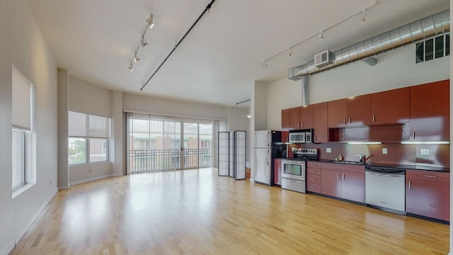 kitchen with appliances with stainless steel finishes, rail lighting, visible vents, and dark countertops