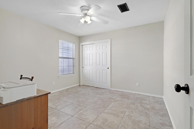 unfurnished room featuring ceiling fan, a textured ceiling, baseboards, and light tile patterned floors