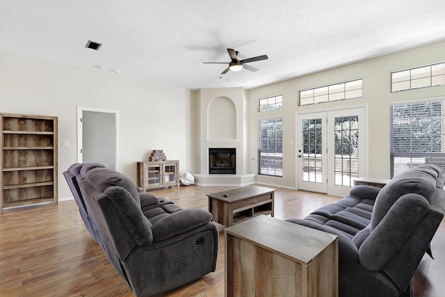 living area with a textured ceiling, a fireplace, and wood finished floors