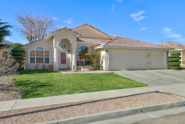 mediterranean / spanish home with a garage, driveway, a front lawn, and stucco siding