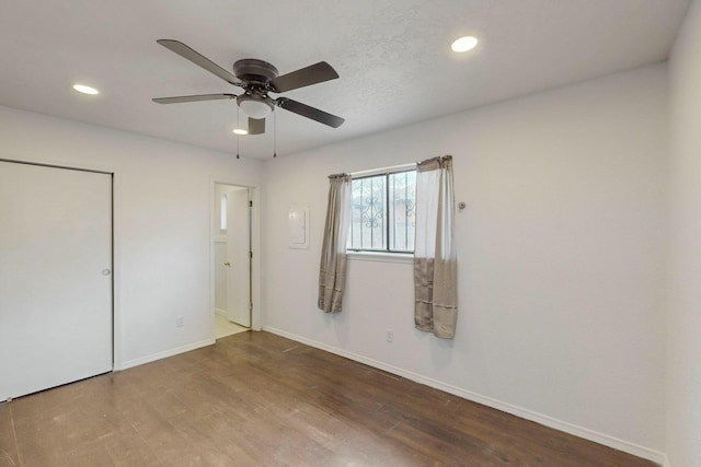 unfurnished bedroom featuring wood finished floors, recessed lighting, a closet, baseboards, and ceiling fan