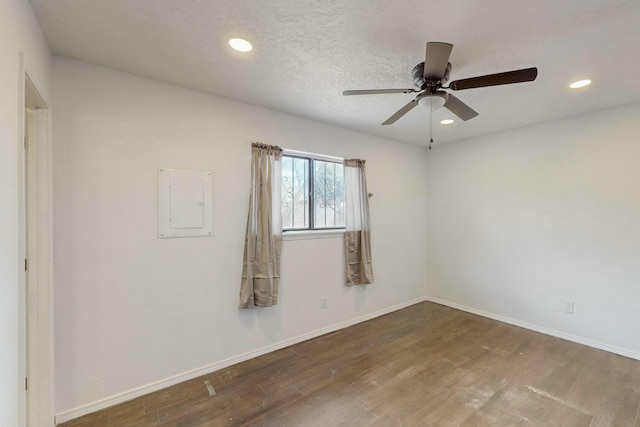 empty room with recessed lighting, baseboards, and wood finished floors