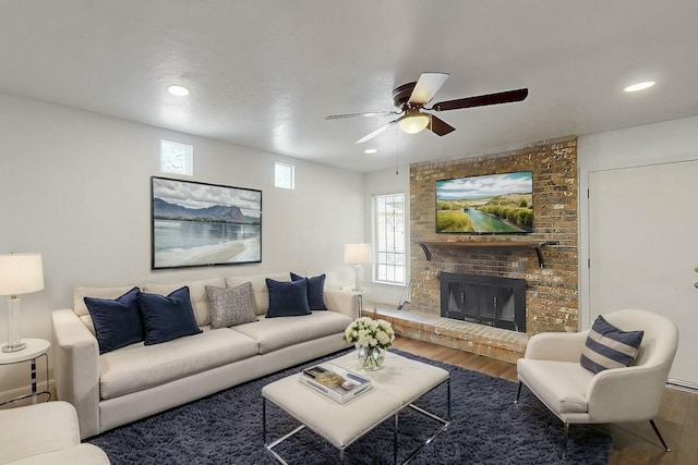 living room featuring a brick fireplace, recessed lighting, wood finished floors, and ceiling fan