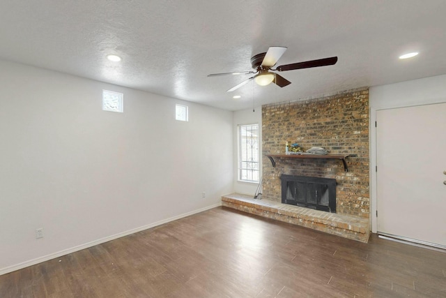 unfurnished living room featuring wood finished floors, plenty of natural light, and a ceiling fan