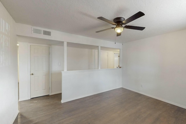 empty room featuring dark wood-style floors, baseboards, visible vents, ceiling fan, and a textured ceiling