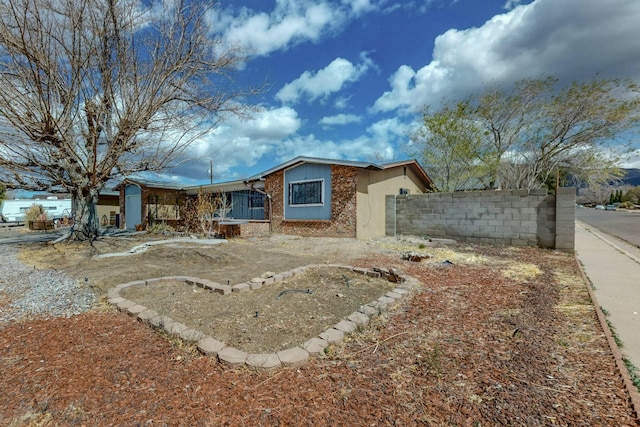 view of front of property featuring brick siding and fence