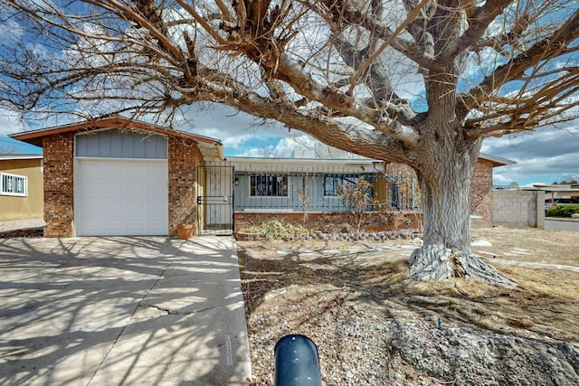 view of front of house with a garage, fence, driveway, and a gate