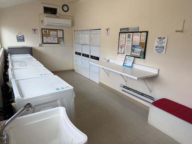 shared laundry area with a wall unit AC, a sink, separate washer and dryer, and tile patterned floors