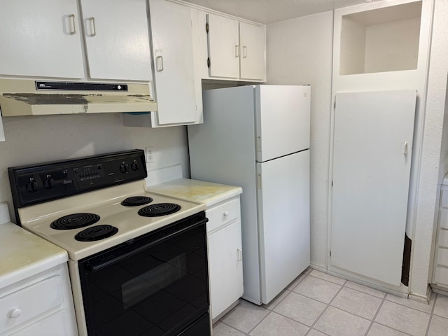 kitchen featuring light tile patterned floors, under cabinet range hood, range with electric stovetop, light countertops, and freestanding refrigerator