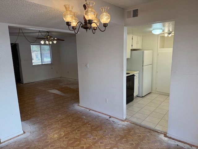 interior space with light countertops, visible vents, electric range, freestanding refrigerator, and a textured ceiling