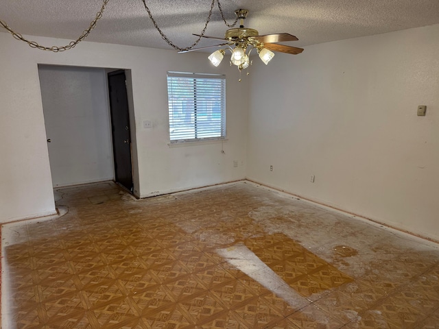 empty room featuring ceiling fan, baseboards, and a textured ceiling