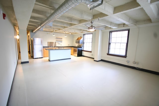 kitchen featuring open floor plan, stainless steel appliances, concrete floors, and dark countertops