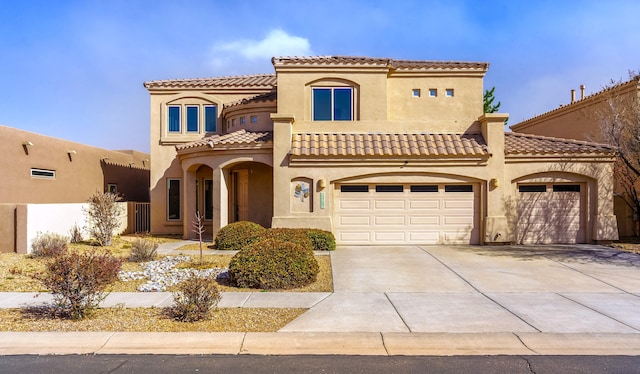 mediterranean / spanish-style house featuring driveway, a tiled roof, and stucco siding