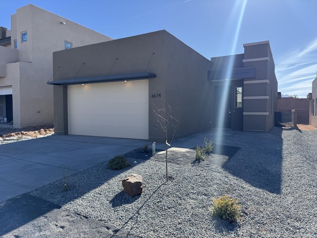 exterior space featuring an attached garage, concrete driveway, stucco siding, and cooling unit