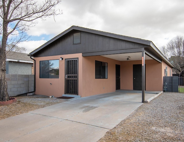 view of front of house with a carport, fence, and driveway