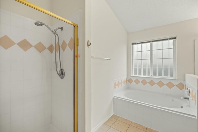 full bath featuring a garden tub, a stall shower, vaulted ceiling, a textured ceiling, and tile patterned floors