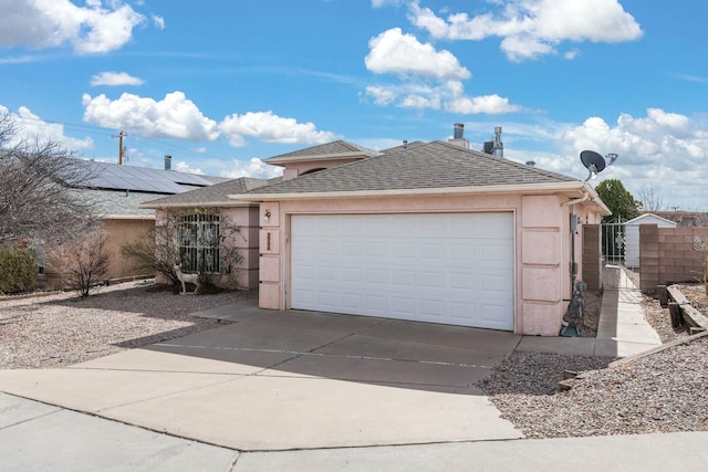 view of front of property with a garage, a shingled roof, concrete driveway, a gate, and stucco siding