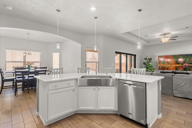 kitchen with open floor plan, light countertops, stainless steel dishwasher, and wood finish floors