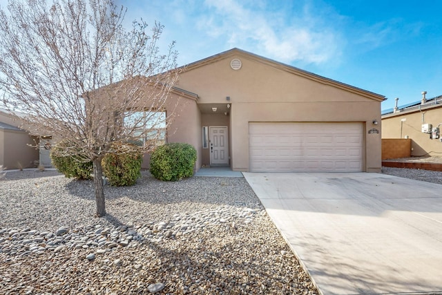 view of front of house featuring concrete driveway, an attached garage, and stucco siding