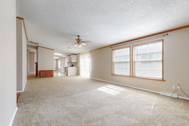 unfurnished living room with a ceiling fan, a healthy amount of sunlight, light carpet, and baseboards