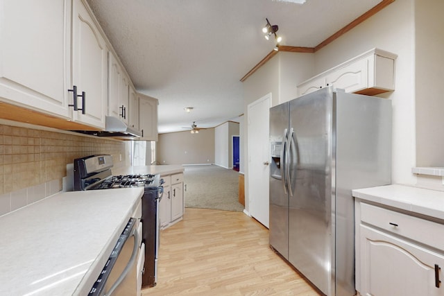 kitchen featuring tasteful backsplash, light wood-style flooring, appliances with stainless steel finishes, a ceiling fan, and open floor plan