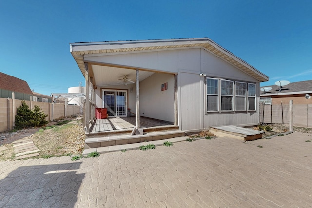 back of property featuring a deck, a fenced backyard, and a ceiling fan