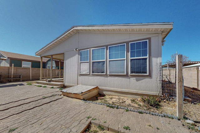 rear view of house featuring fence