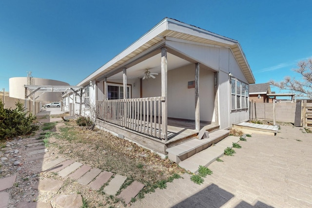 view of front of home with fence and a ceiling fan