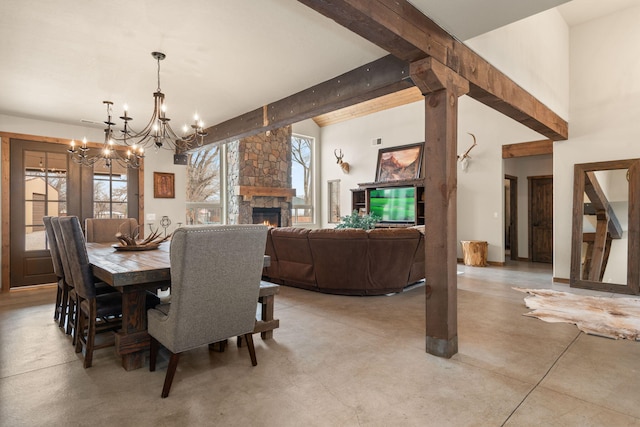 1800 Los Pinos Rd, Bosque Farms, NM 87068 - dining room featuring a chandelier, concrete flooring, beam ceiling, and a fireplace