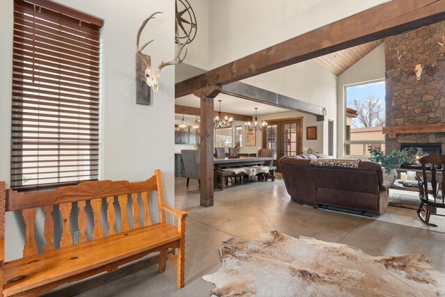 1800 Los Pinos Rd, Bosque Farms, NM 87068 - living area with a chandelier, finished concrete flooring, high vaulted ceiling, beamed ceiling, and a stone fireplace