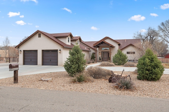 view of front of house featuring a garage, driveway, and stucco siding