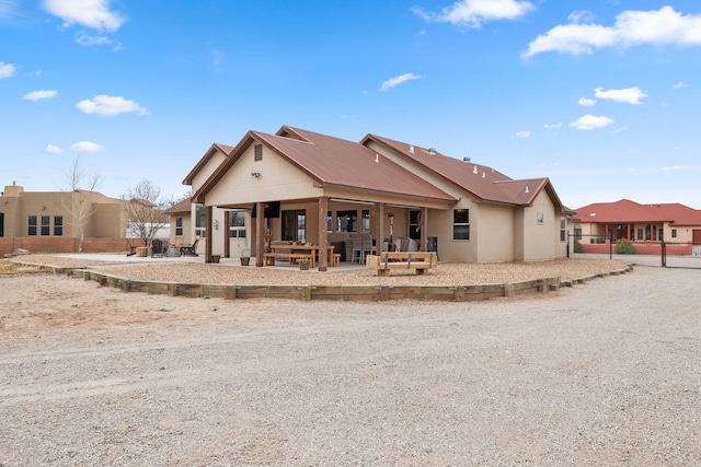 rear view of house featuring a patio area and metal roof