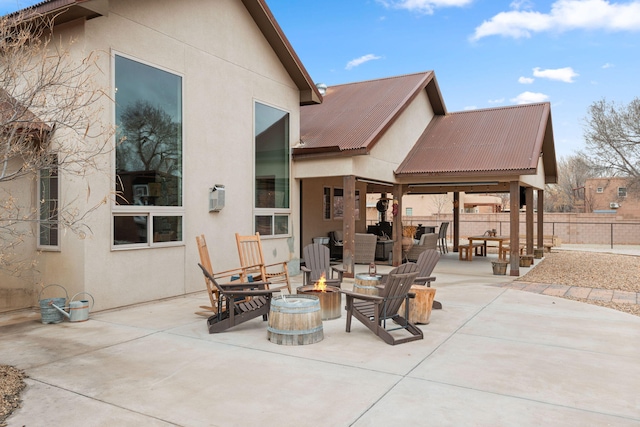 view of patio featuring fence and a fire pit