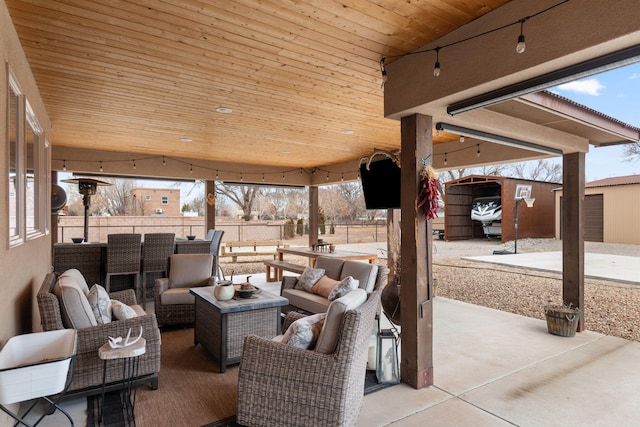 view of patio / terrace with an outbuilding, outdoor lounge area, and fence