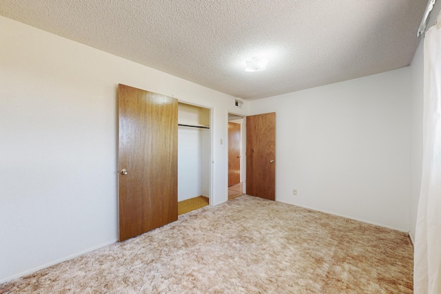 unfurnished bedroom featuring a textured ceiling, a closet, visible vents, and carpet flooring