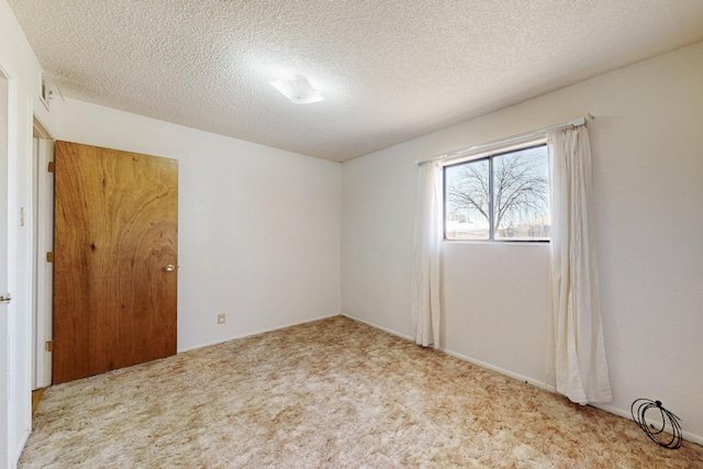 carpeted spare room featuring a textured ceiling