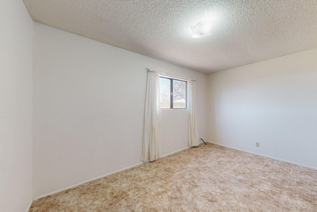 carpeted empty room with a textured ceiling