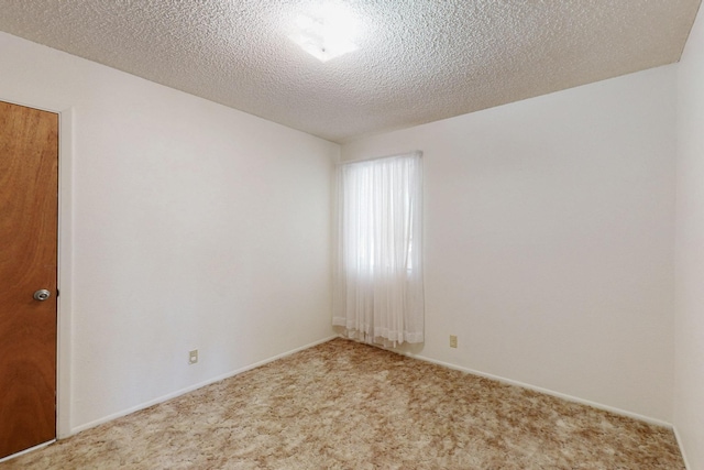 empty room with carpet floors and a textured ceiling