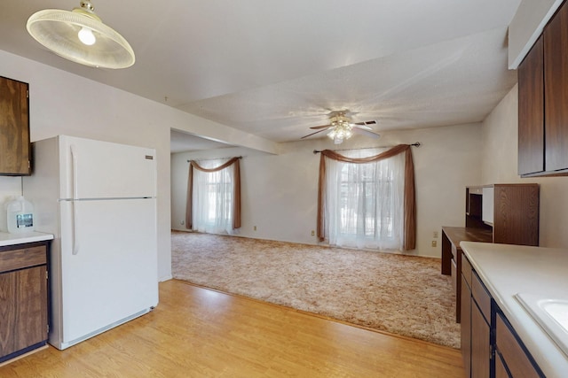 kitchen featuring light carpet, light countertops, light wood-style flooring, and freestanding refrigerator