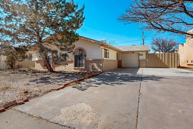 single story home featuring an attached garage, brick siding, driveway, a gate, and stucco siding