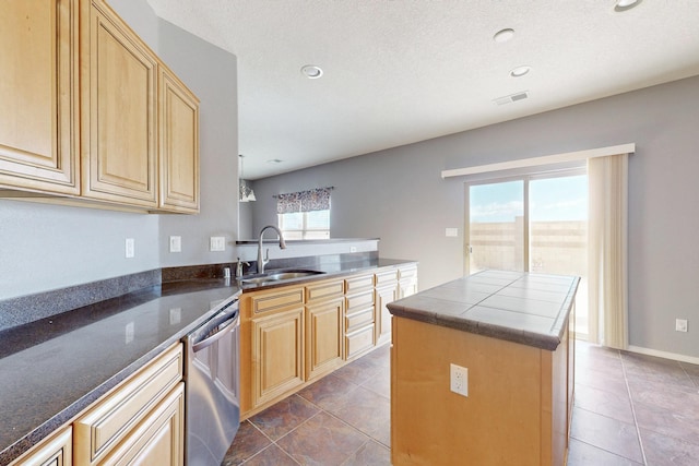 kitchen with tile patterned floors, a sink, dishwasher, and light brown cabinetry