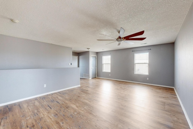 spare room with visible vents, a ceiling fan, light wood-style flooring, and baseboards