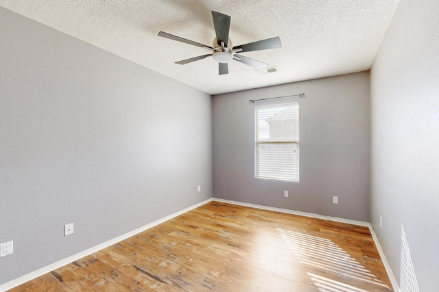 unfurnished room with baseboards, visible vents, ceiling fan, and light wood finished floors