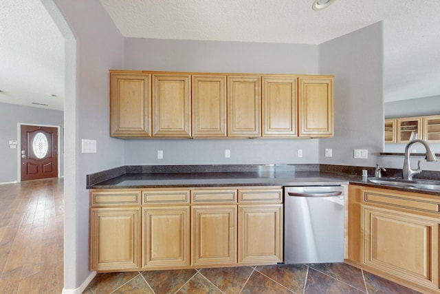 kitchen featuring a sink, dark countertops, arched walkways, and stainless steel dishwasher