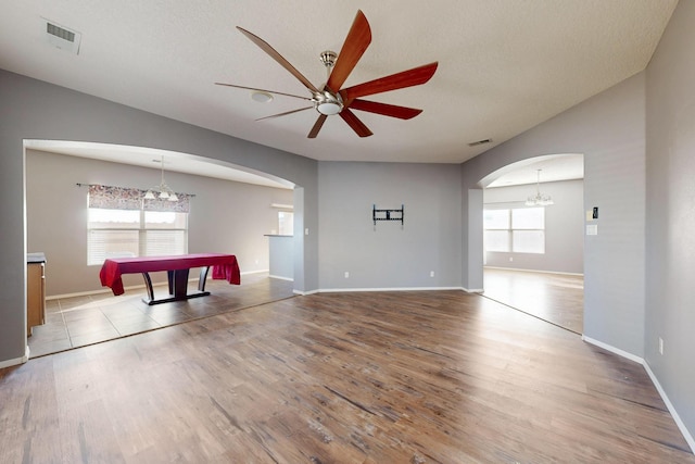 interior space featuring arched walkways, visible vents, and wood finished floors