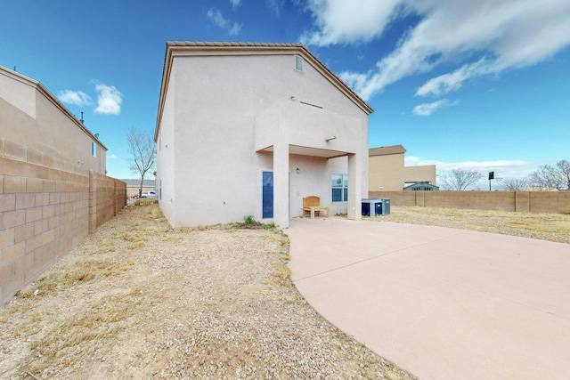 back of house with cooling unit, fence, a patio, and stucco siding